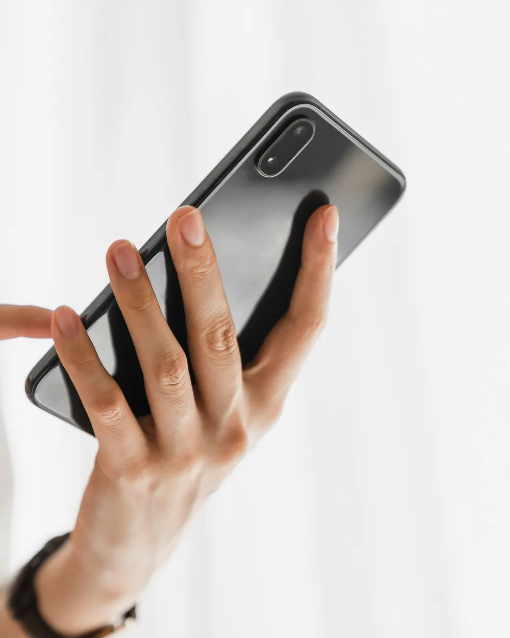 Mão digitando uma mensagem no WhatsApp pelo celular